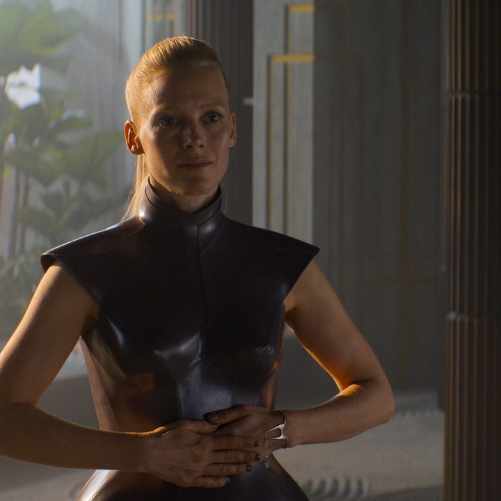 Laura Birn stands with her arms across her stomach in Foundation.