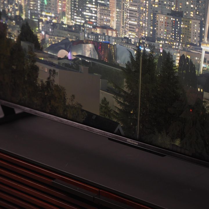 The bottom bezel and logo of a Hisense U8K TV with a city skyline at night displayed.