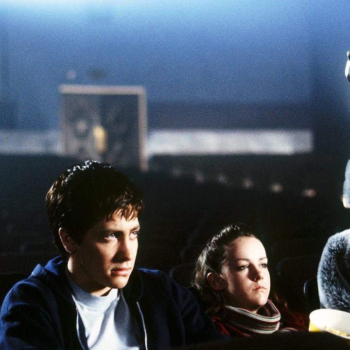 Jake Gyllenhaal and Jena Malone as Donnie and Gretchen at the movies sitting besides a giant rabbit in Donnie Darko.