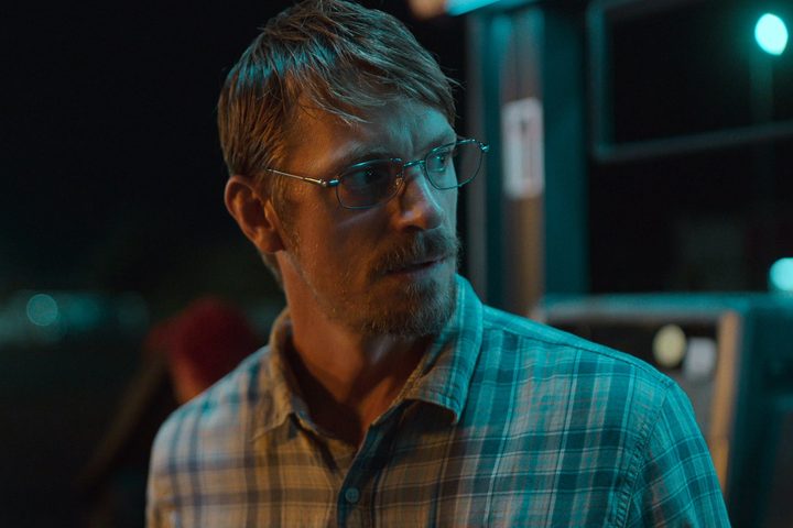 Joel Kinnaman stands near a gas pump in Sympathy for the Devil.