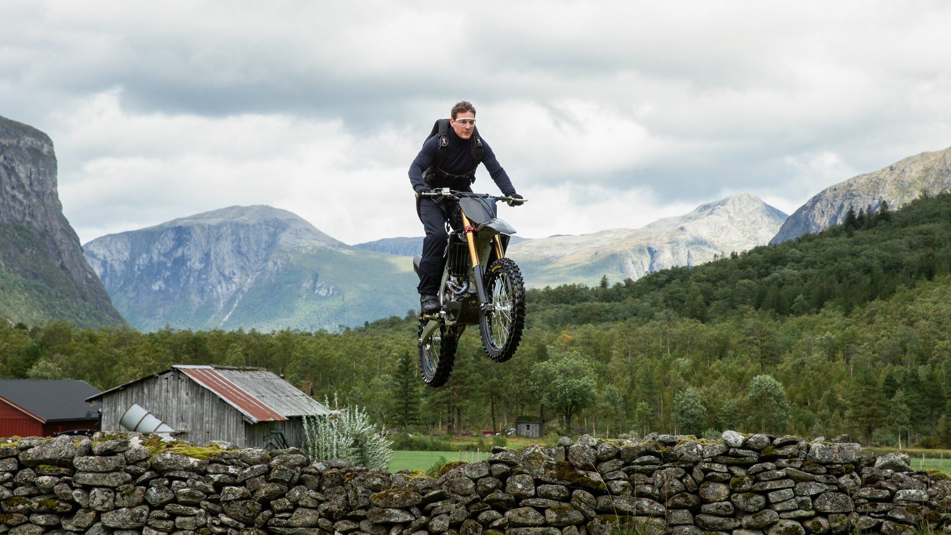 Tom Cruise does a little jump on a motorcycle.