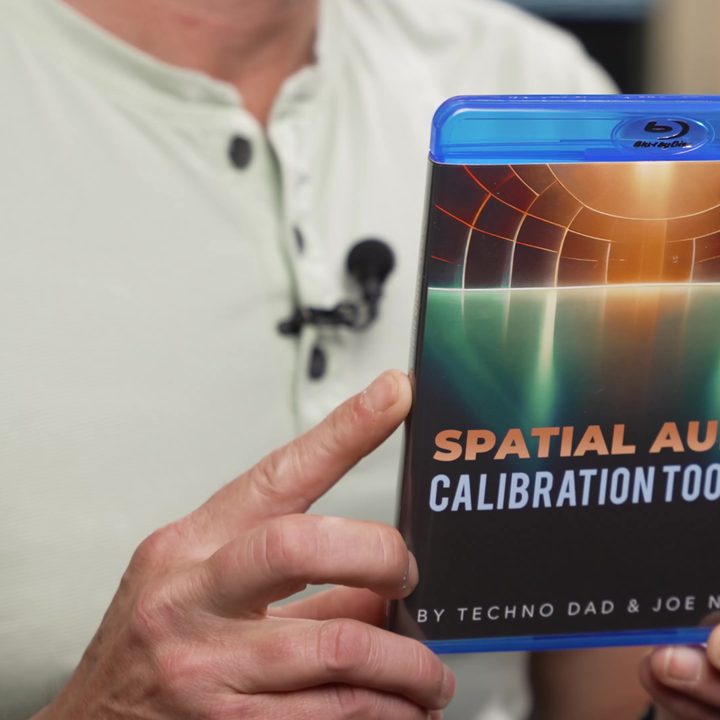 A man holding the box for the Spatial Audio Calibration Toolkit disc.