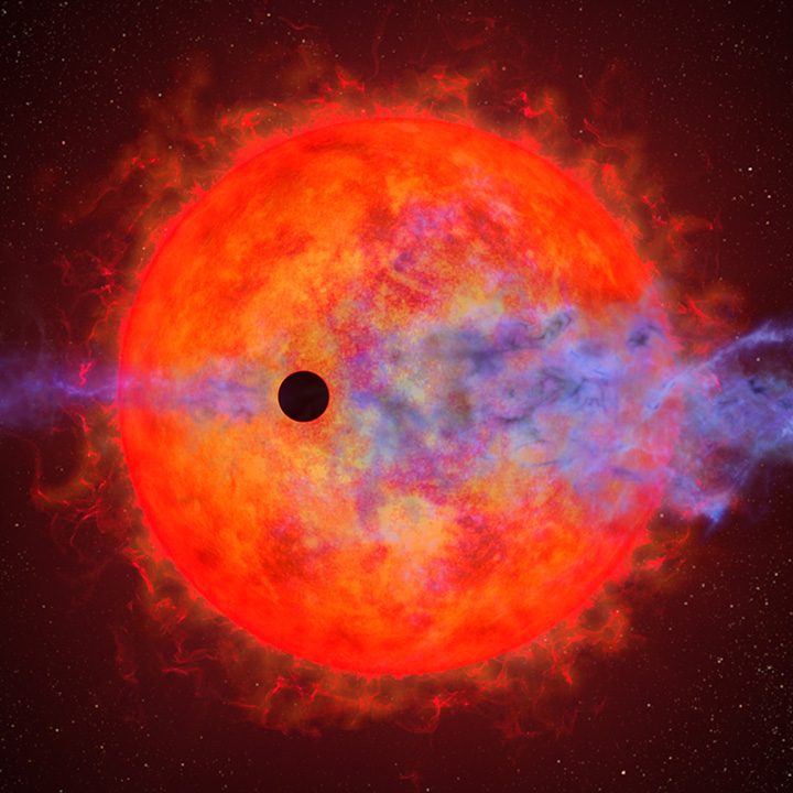 This artist's illustration shows a planet (dark silhouette) passing in front of the red dwarf star AU Microscopii.