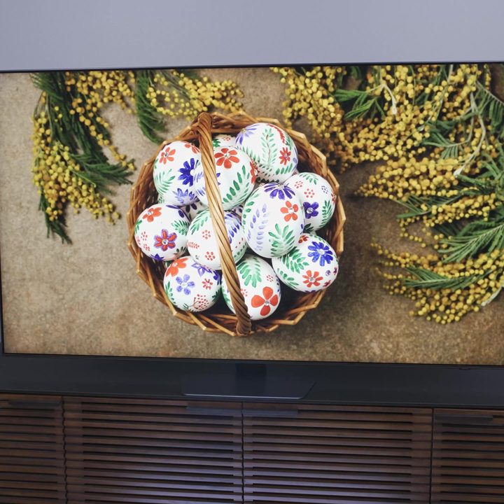 Brightly colored painted eggs in a bowl shown on a Samsung QN90C.