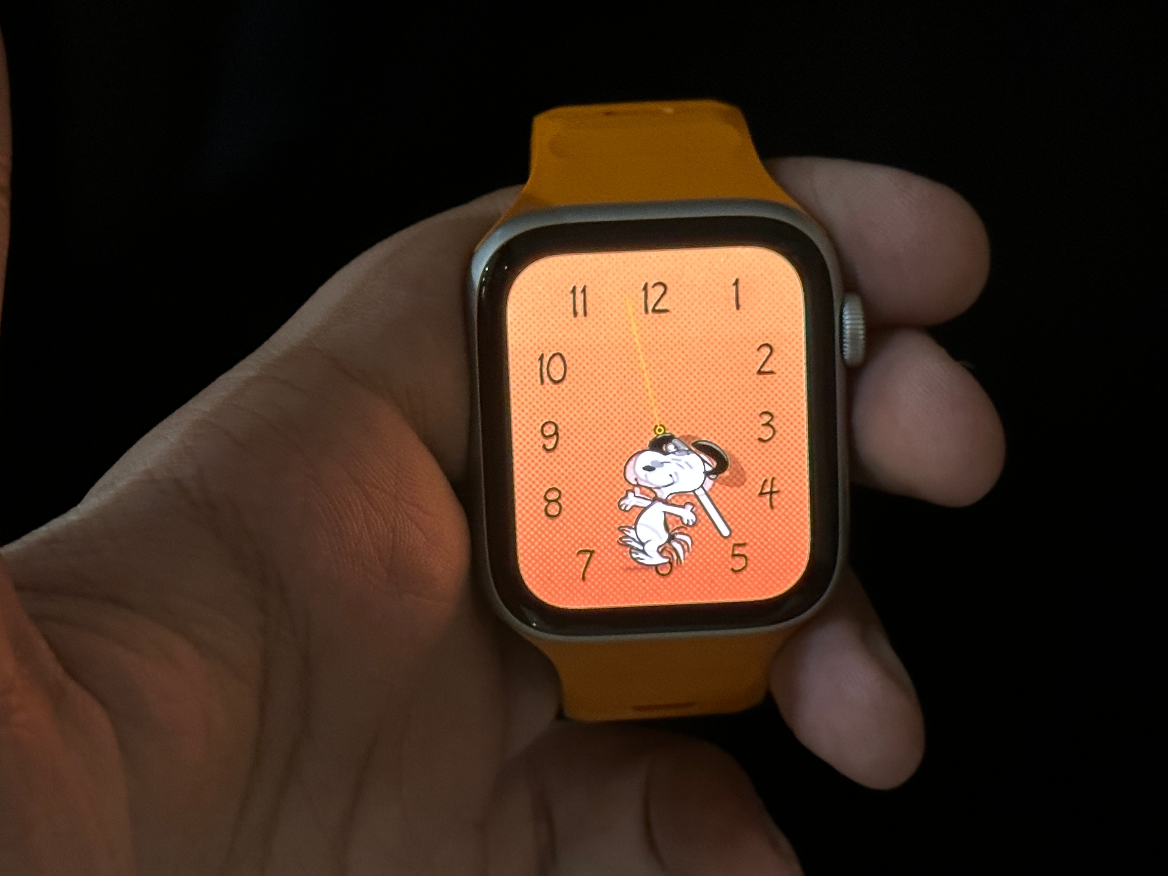Snoopy Watch Face with Pumpkin background on Apple Watch SE.