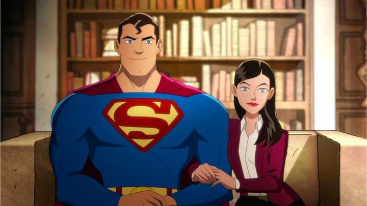 Superman and Lois Lane sitting on a couch and looking at the camera in the animated show Harley Quinn,