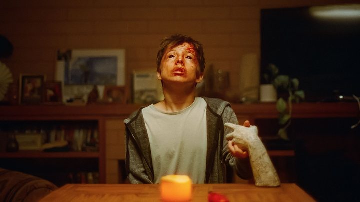 Joe Bird holds an unholy ceramic hand, his face bruised and bloodied.
