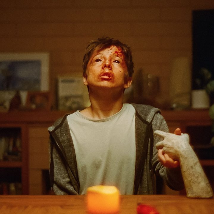 Joe Bird holds an unholy ceramic hand, his face bruised and bloodied.