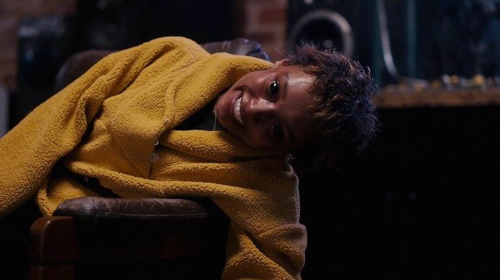 A possessed Sophie Wilde turns sideways with a very spooky grin on her face in "Talk to Me."