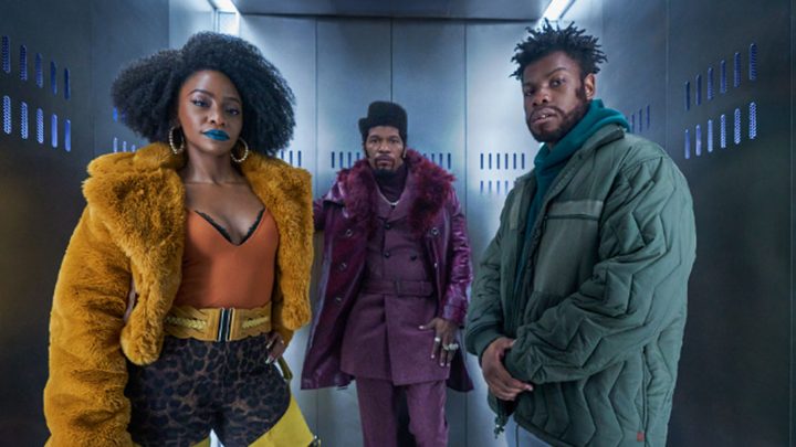 The cast of They Cloned Tyrone inside an elevator looking directly at the camera.