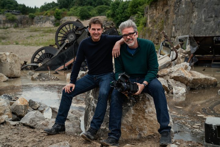 Tom Cruise and Christopher McQuarrie sit on a rock together on the set of Mission: Impossible - Dead Reckoning Part One.