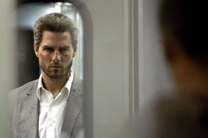 Tom Cruise looks through a train compartment door in Collateral.
