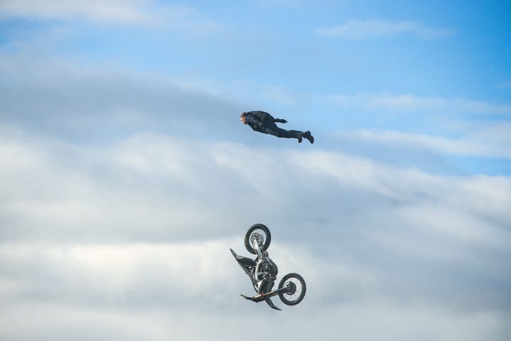 Tom Cruise soars above a falling motorcycle in Mission: Impossible - Dead Reckoning Part One.