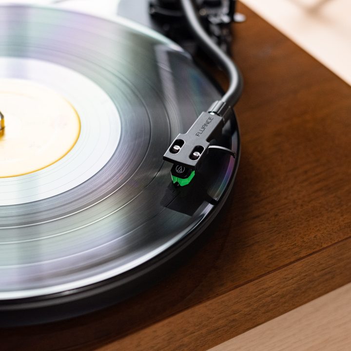 A close-up of the Fluance RT81+ turntable in walnut.