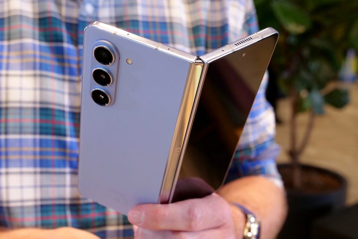 A person holding the half open Samsung Galaxy Z Fold 5.