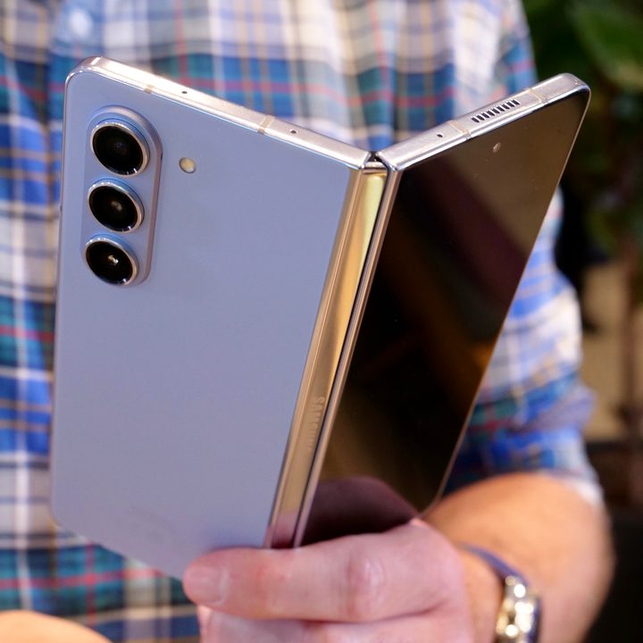 A person holding the half0open Samsung Galaxy Z Fold 5.