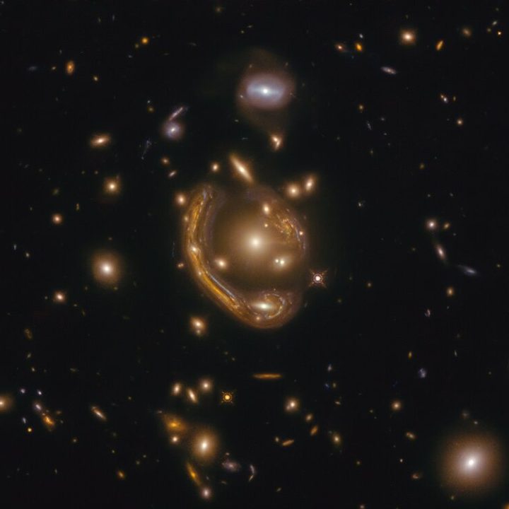 An image taken from the Hubble Space Telescope shows the distortion of "gravitational lensing," which reveals the effects of dark matter, even though we can't see it.