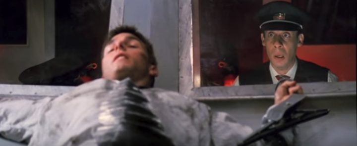 A man lies on a train in Mission: Impossible.