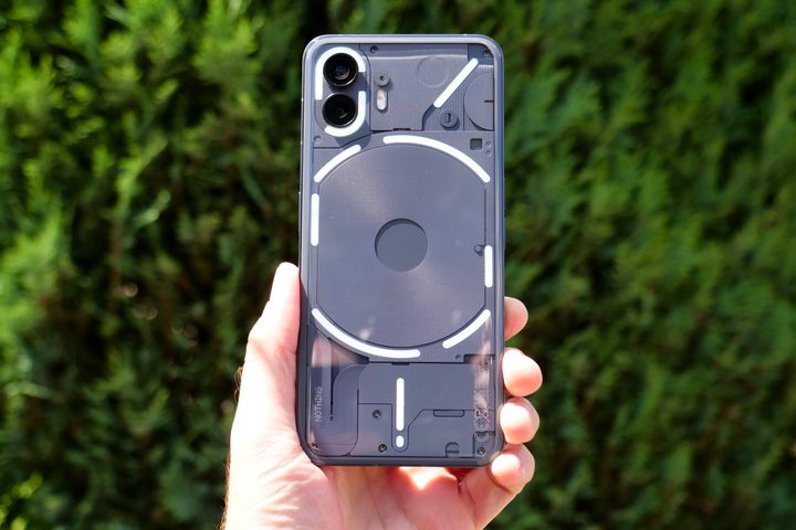 A person holding the Nothing Phone 2, with the lights lit up.