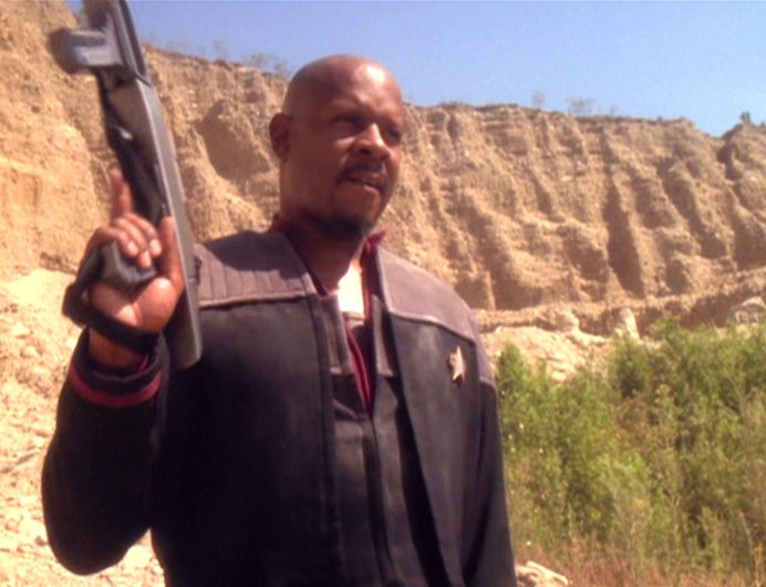 Captain Sisko brandishes a phaser rifle outdoors in the DS9 episode "Rocks and Shoals"
