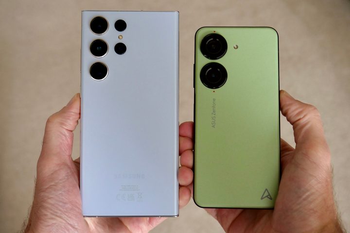 A person holding the Galaxy S23 Ultra and the Asus Zenfone 10, showing the size of the phones.
