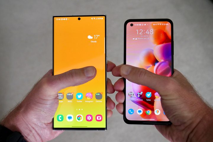 A person holding the Galaxy S23 Ultra and the Asus Zenfone 10, showing the screen size.