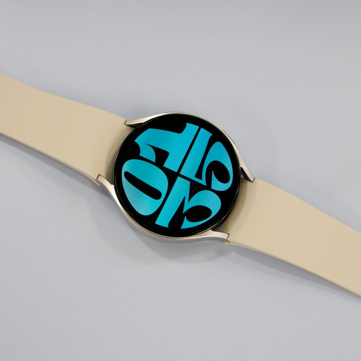 The Samsung Galaxy Watch 6 lying on a table with its screen turned on.