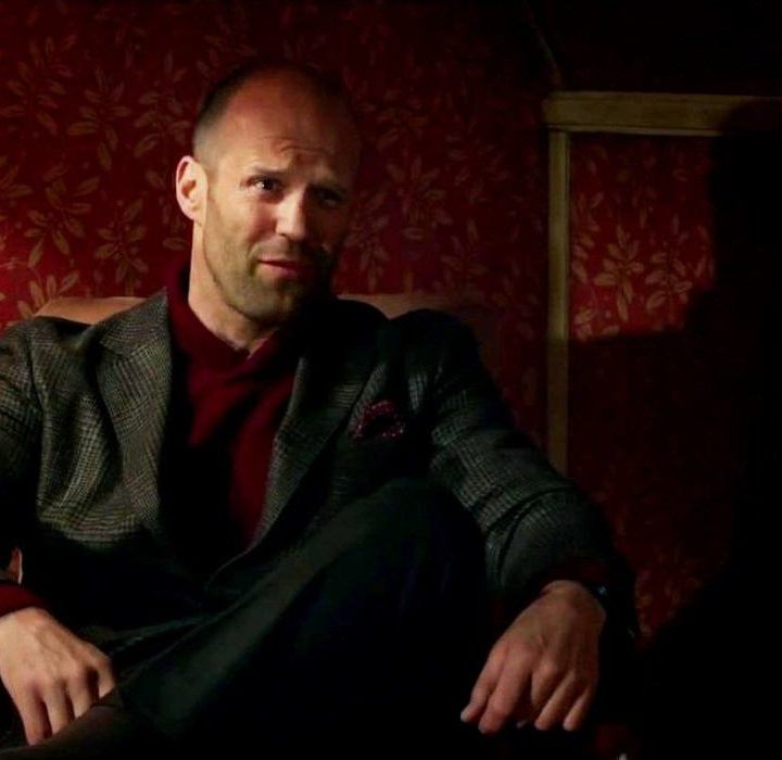 Jason Statham sits in a chair in Spy (2015).