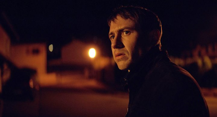 A man looks concerned while standing in The Night of the 12th.