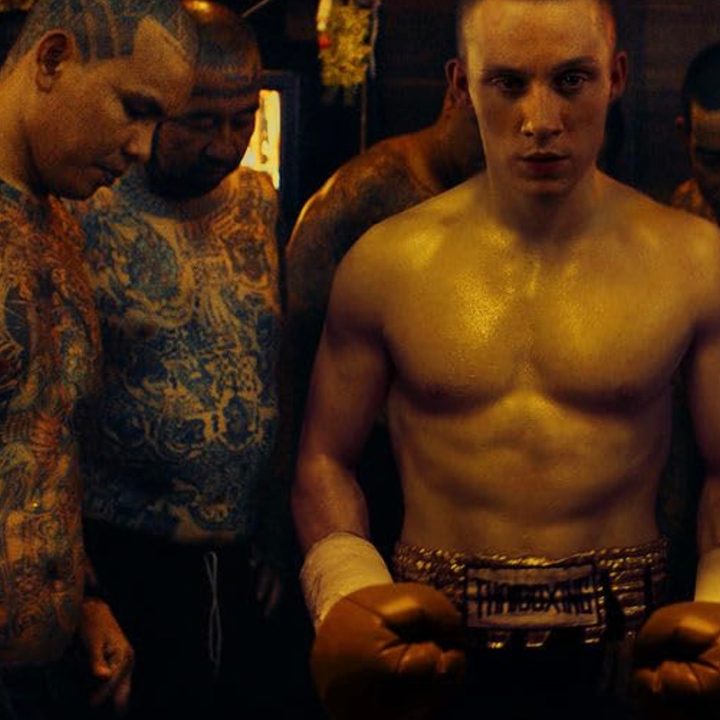 A boxer stands beside men in A Prayer Before Dawn.