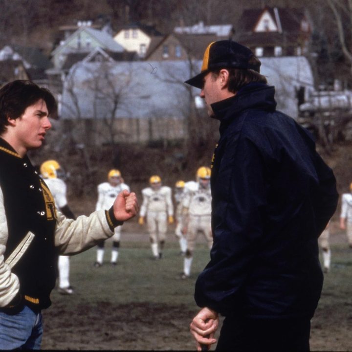 A football player talks to a football coach on the field in All The Right Moves.