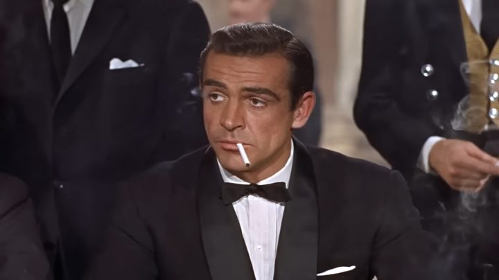 James Bond in "Dr. No" smoking a cigarette in a tuxedo.