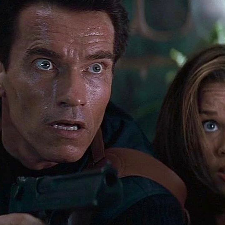 Arnold Schwarzenegger sits next to Vanessa Williams and stares in Eraser.