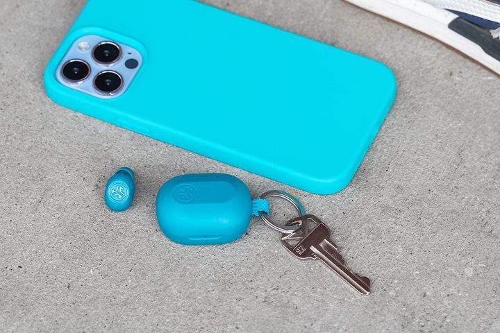 JLab JBuds Mini seen with keys, next to an iPhone.