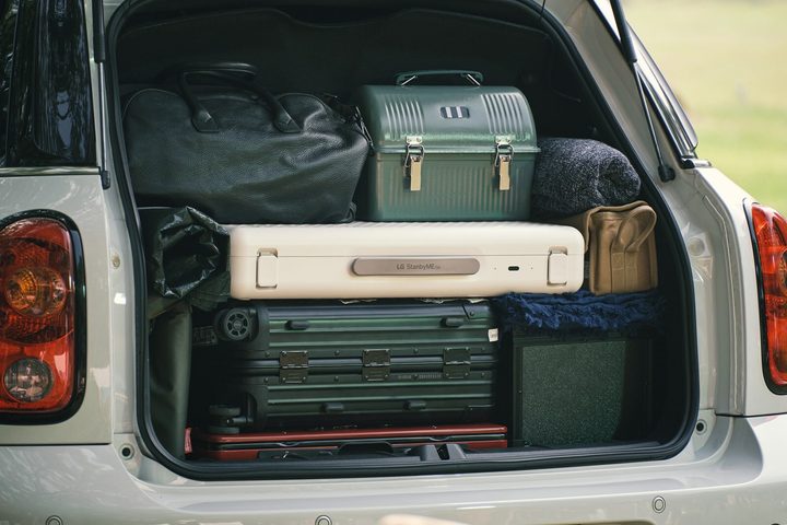 LG StanbyMe Go 27-inch touchscreen suitcase TV packed in a car trunk.