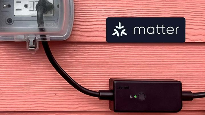 The Leviton Outdoor Smart Plug plugged into an outlet in front of red siding.