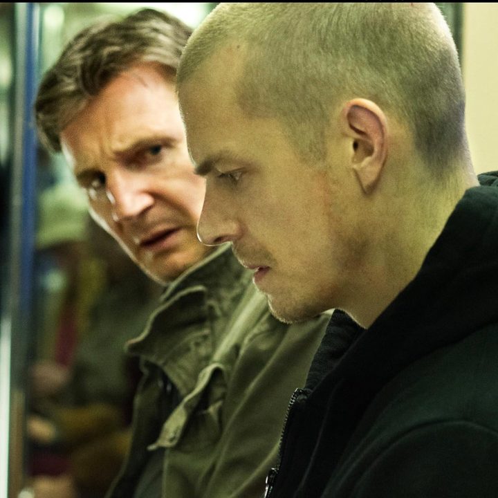 A man sits next to another man while staring down in Run All Night.