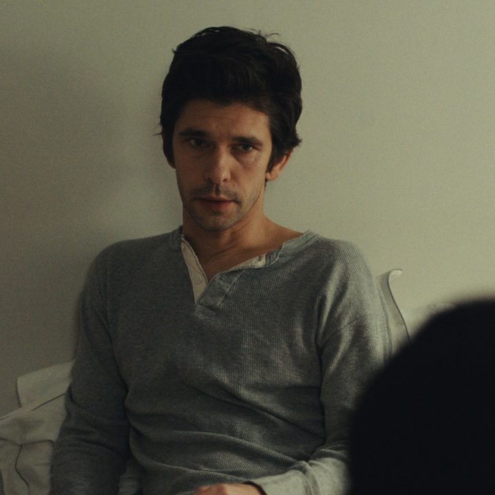 Ben Whishaw looks contemplative sitting in bed.