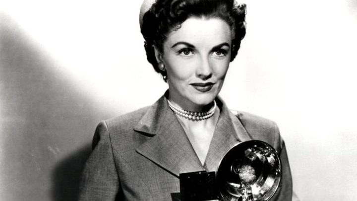 Phyllis Coates as Lois Lane holding a camera in Adventures of Superman.