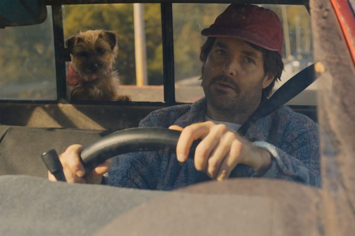 Reggie looks at Doug through a truck window in Strays.