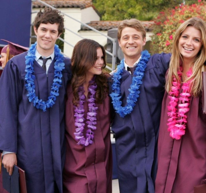 Four teenagers stand next to each other in graduation gowns in The O.C.