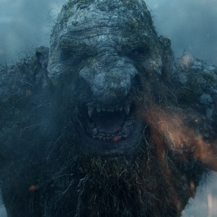 A giant troll stands in front of fire in Troll.
