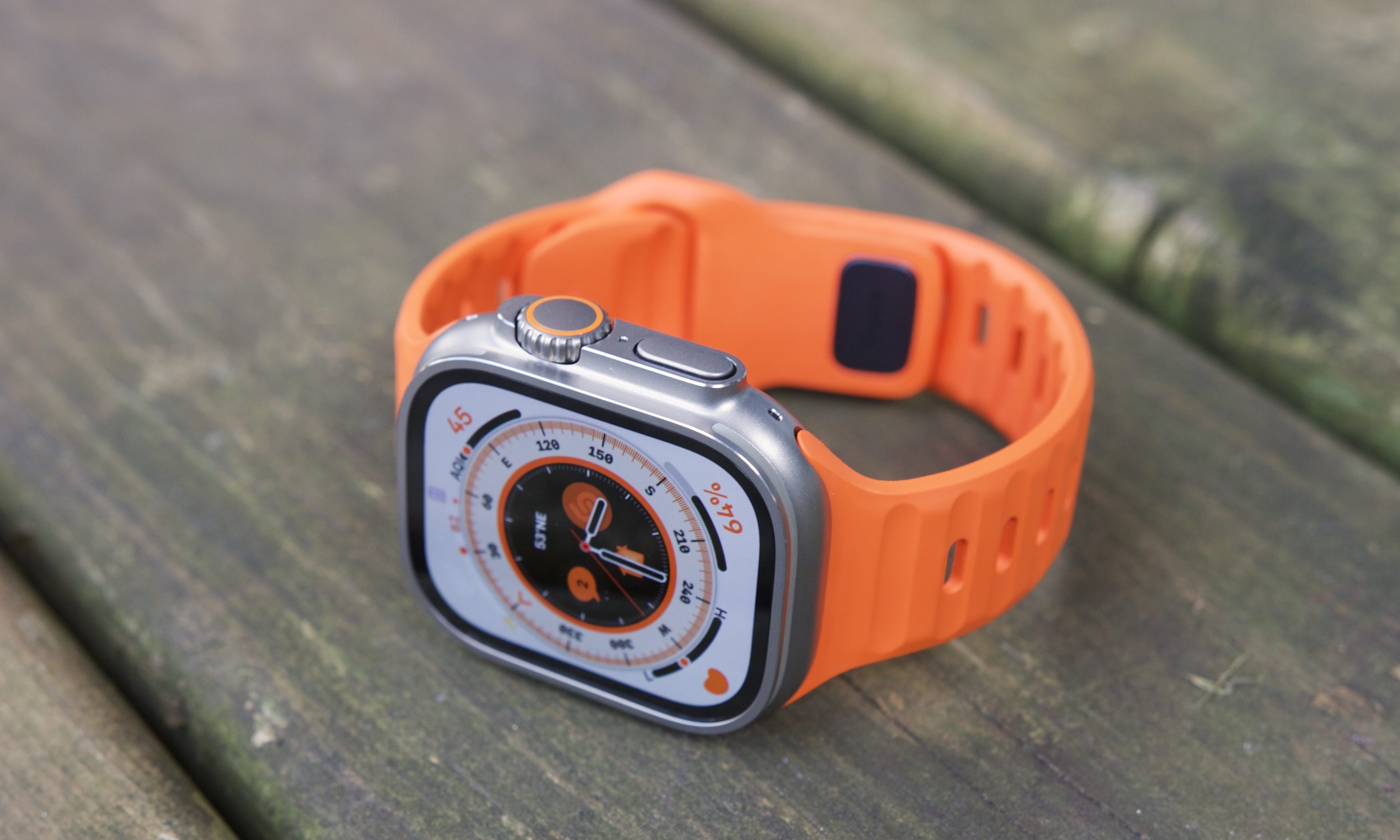Overhead view of an Apple Watch Ultra resting on a wooden patio.