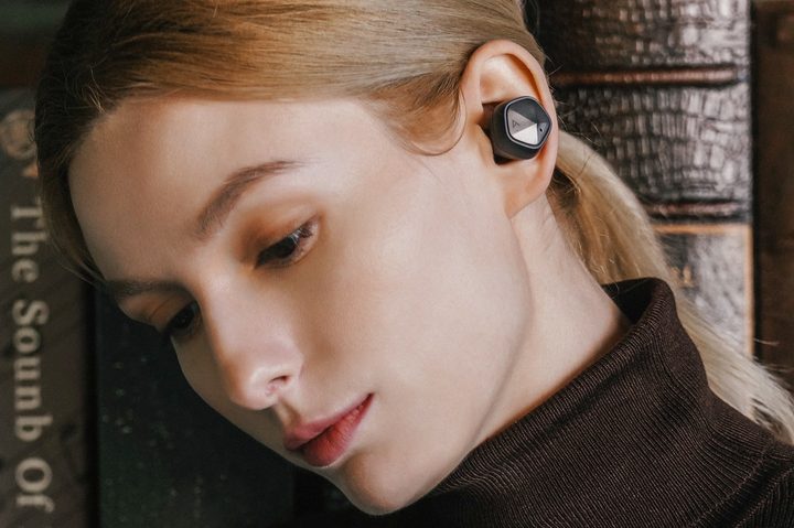 Woman wearing Astell&Kern UW100 MK II wireless earbuds.