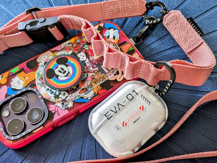 Casetify's Utility Crossbody Lanyard strap with iPhone 14 Pro and AirPods Pro Case attached.