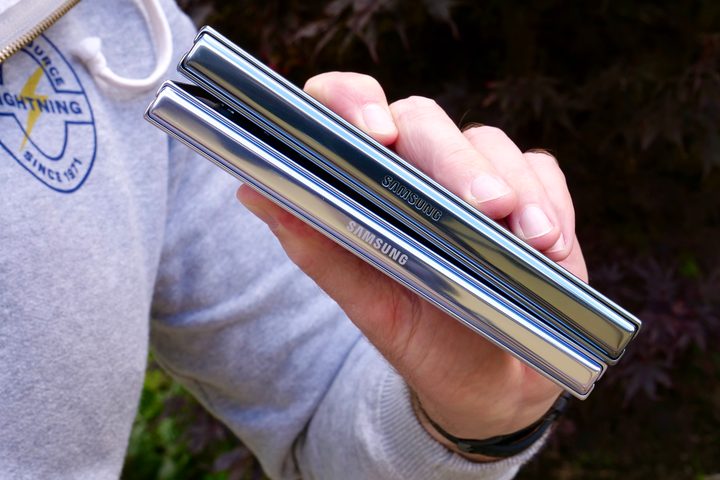 A person holding the Samsung Galaxy Z Fold 5 and the Galaxy Z Fold 4, showing the hinges.