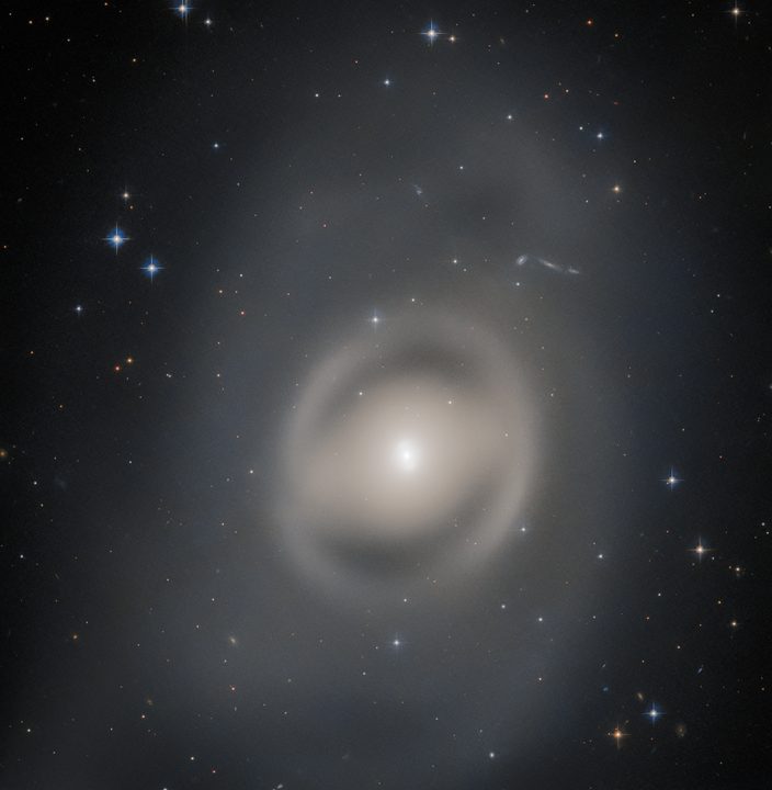 The lenticular galaxy NGC 6684 bathes this image from the NASA/ESA Hubble Space Telescope in a pale light. Captured with Hubble’s Advanced Camera for Surveys, this galaxy is around 44 million light-years from Earth in the constellation Pavo. Pavo – the Latin name for peacock – is a constellation in the southern sky and one of four constellations collectively known as the Southern Birds.