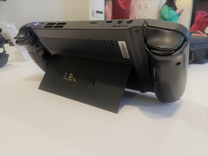 A Legion Go stands on a table, resting on its kickstand.
