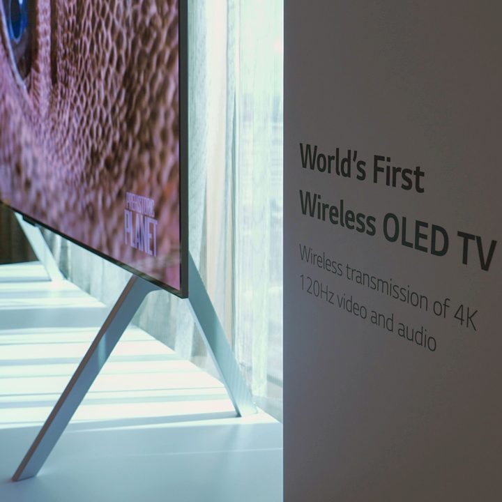 Profile view of the sligm LG M-Series OLED TV next to promotional material at CES.