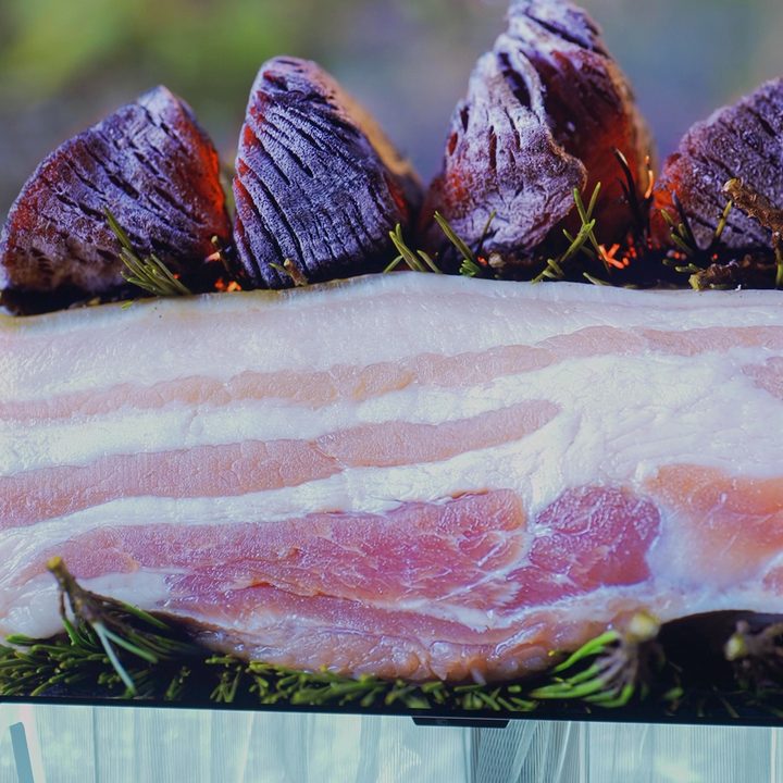 Close up of slab bacon on a bed of rosemary displayed on an LG M-Series OLED.